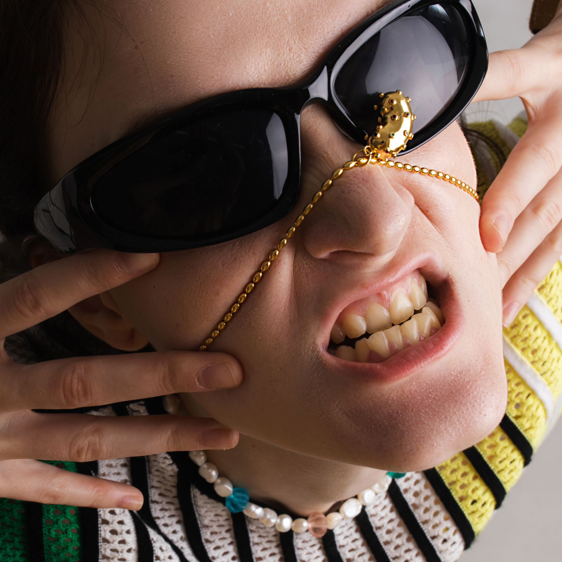 Model wearing golden Oval chain with a bean pendant. Gold plated silver