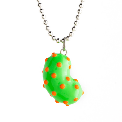 A silver bean pendant enveloped in lush green enamel, accented with playful orange dots