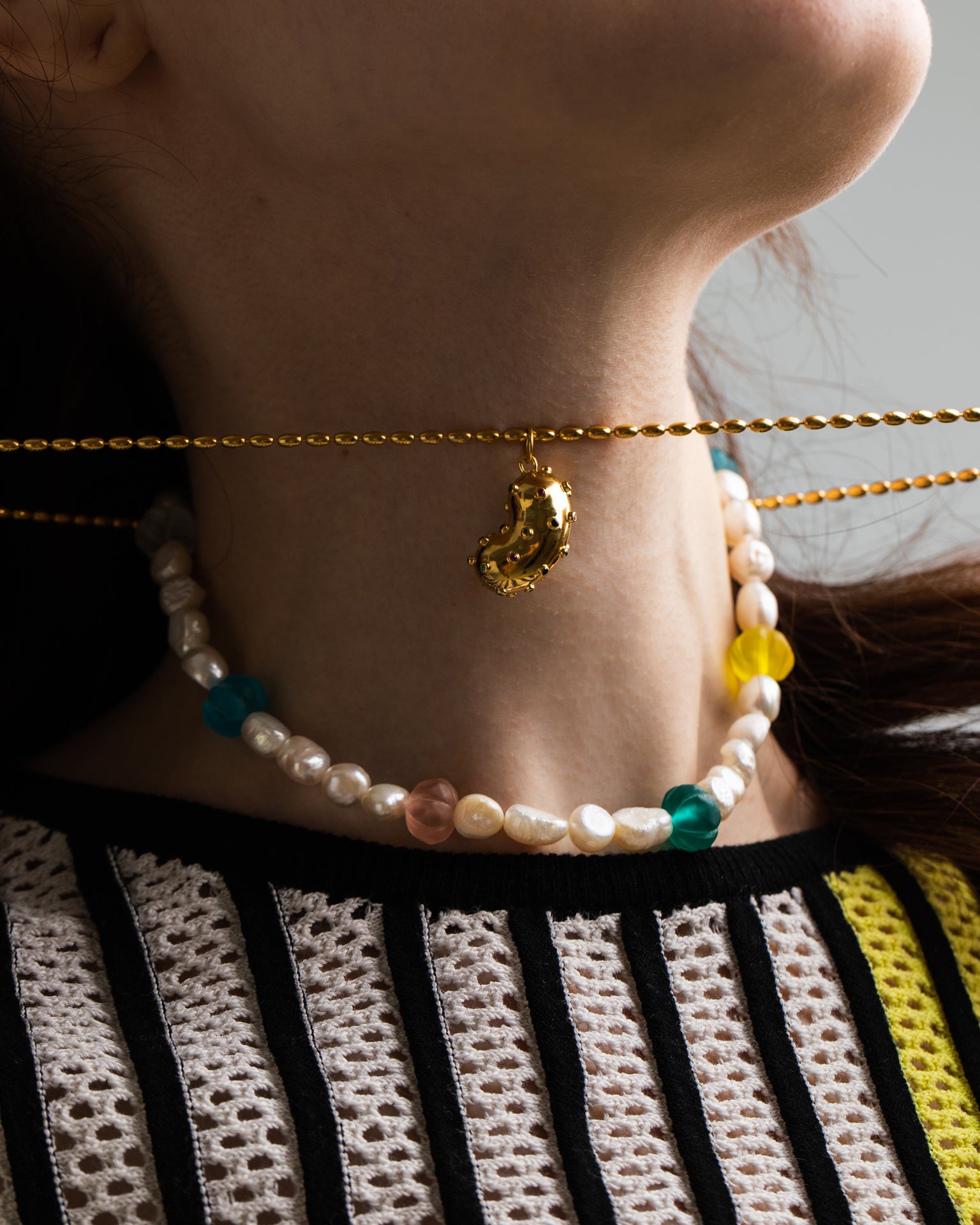 Model wearing Bean pendant made of gold plated silver and natural sapphires