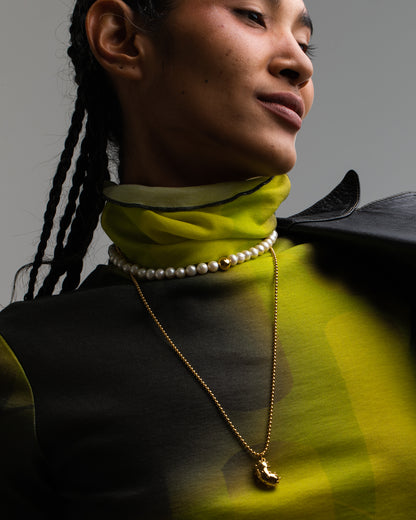 Model wearing Bean pendant made of gold plated silver, natural sapphires, tsavorite and peridotModel with black sunglasses wearing Bean pendant made of gold plated silver, natural sapphires, tsavorite and peridot