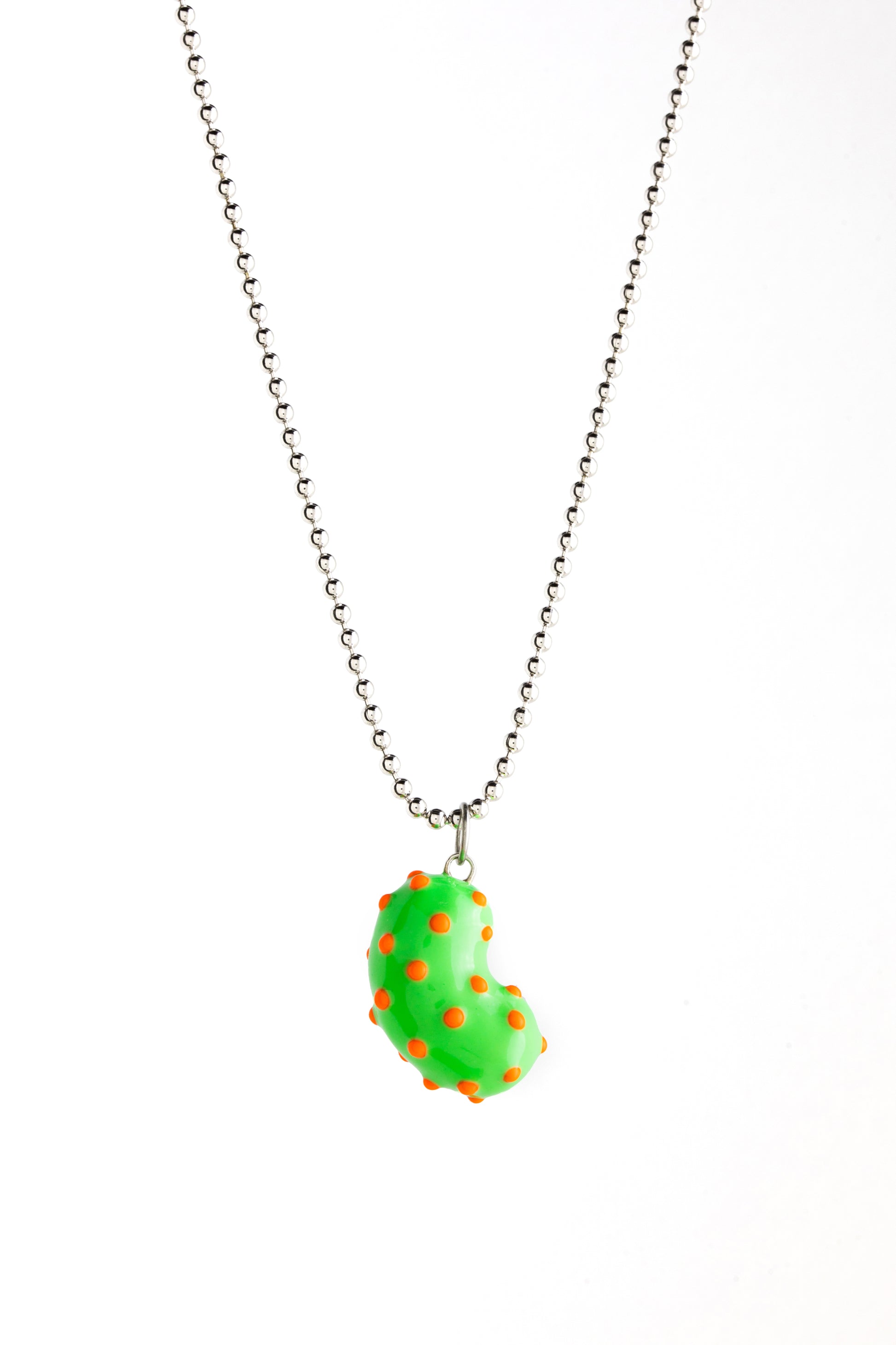 A silver bean pendant enveloped in lush green enamel, accented with playful orange dots