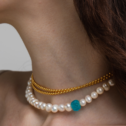 Model wearing necklace made of an old glass bead, freshwater pearls and 925 rhodium plated silver