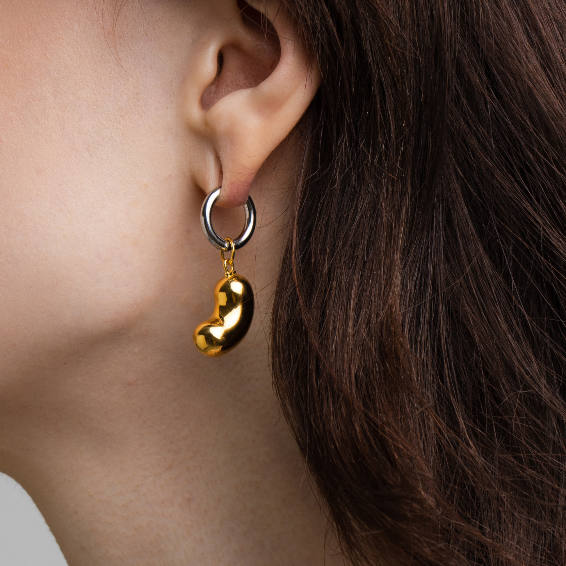 model wearing bean pendant made of gold-plated silver with an earring 